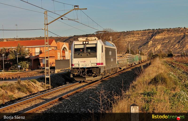 253-085 a cargo de un tren de traviesas en Cenicer